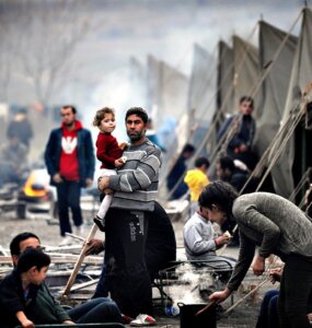 A Syrian refugee holds a baby in a refug...A Syrian refugee hold